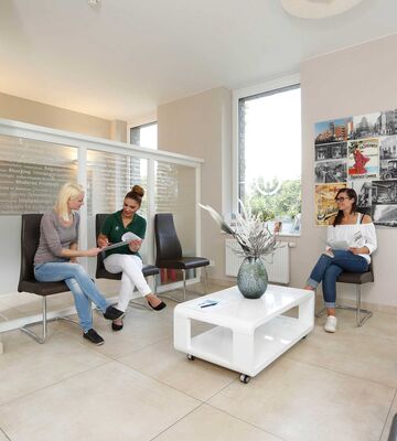 Der Wartebereich unserer Zahnarztpraxis in Hannover Limmer am Leinepark, Kunden warten auf Bänken